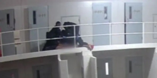 Officers hold Terry Lee Thurmond down to the ground, appearing to kneel on his back, neck and shoulders. Thurmond appears to begin hanging over the 2nd floor railing. 