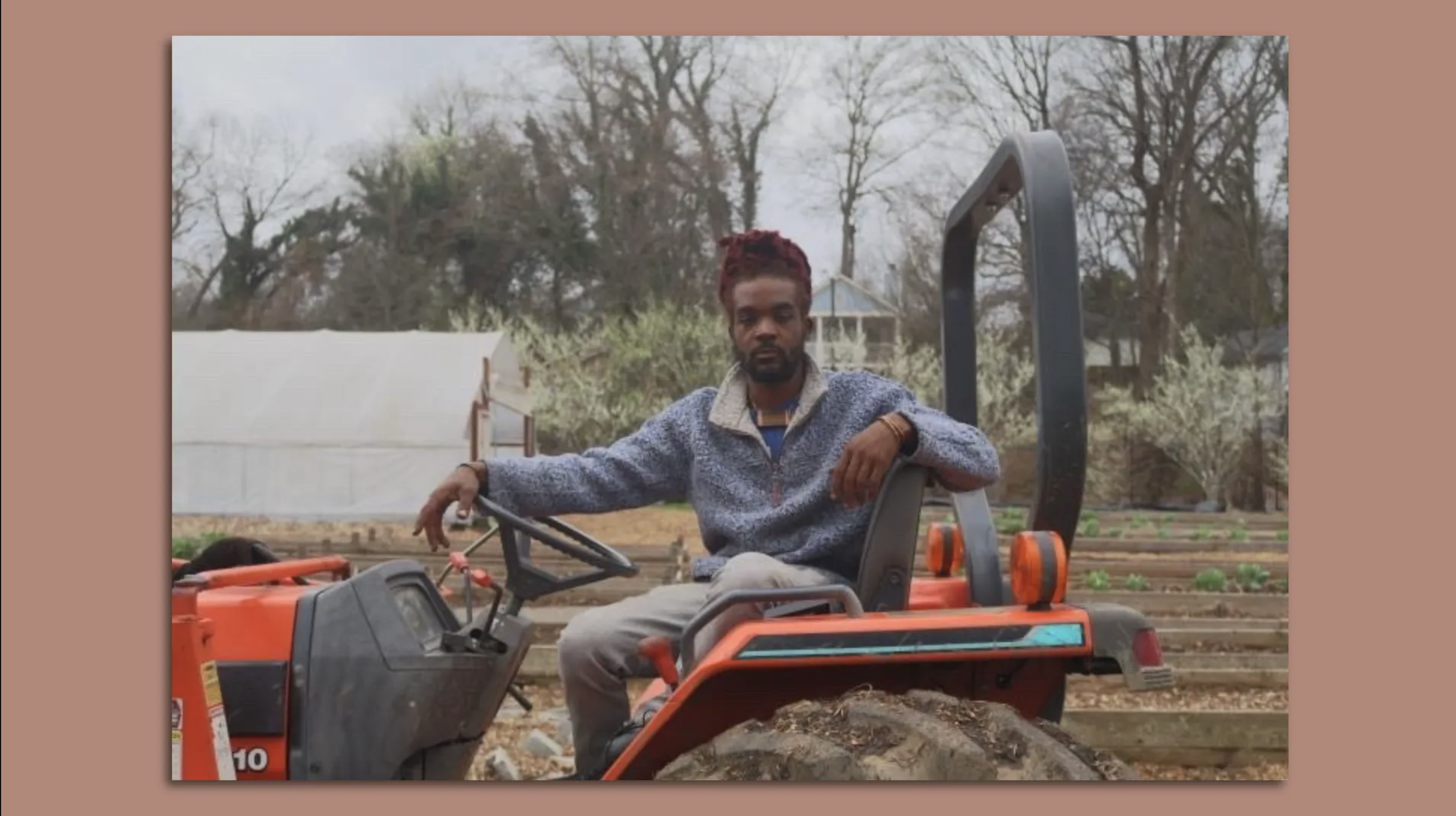 Jeremy Amico sits on a tractor in an urban farm setting