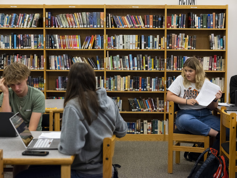 Junior at Robert Lee High School Ammileigh Smith, right, talks with her classmates about an essay she wrote about the pros and cons of school vouchers in Texas, in the school’s library in Robert Lee, Texas on March 9, 2023.