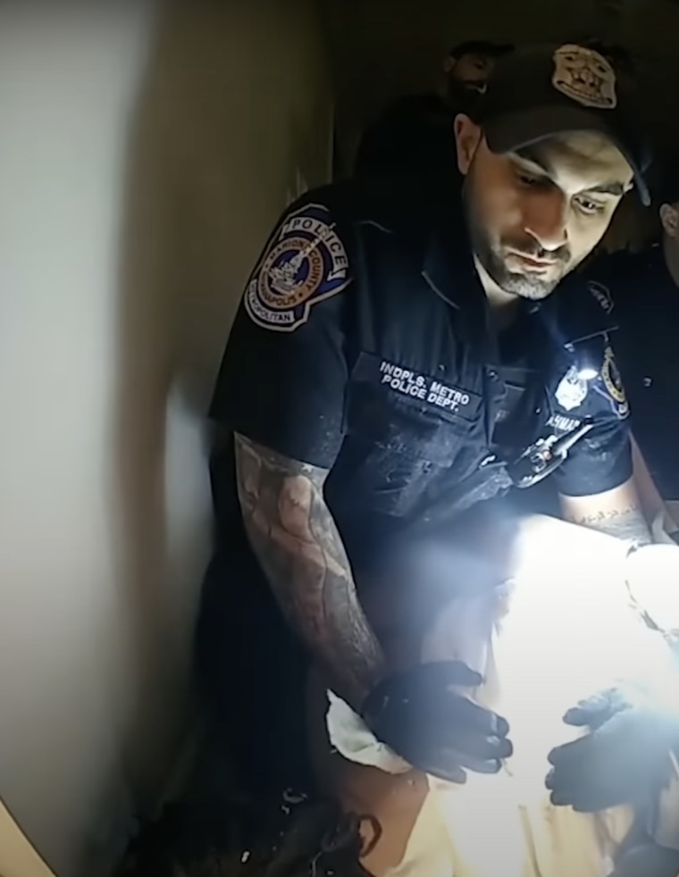 Officers hold Herman Whitfield III in handcuffs while they wait for medics to arrive.