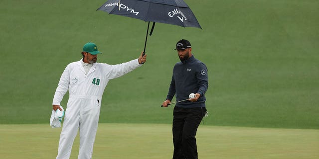 Jon Rahm of Spain looks over a putt on the second green with his caddie Adam Hayes during the third round of the 2023 Masters Tournament at Augusta National Golf Club April 8, 2023, in Augusta, Ga.