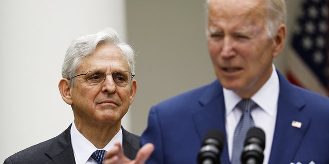 Merrick Garland looks at Joe Biden