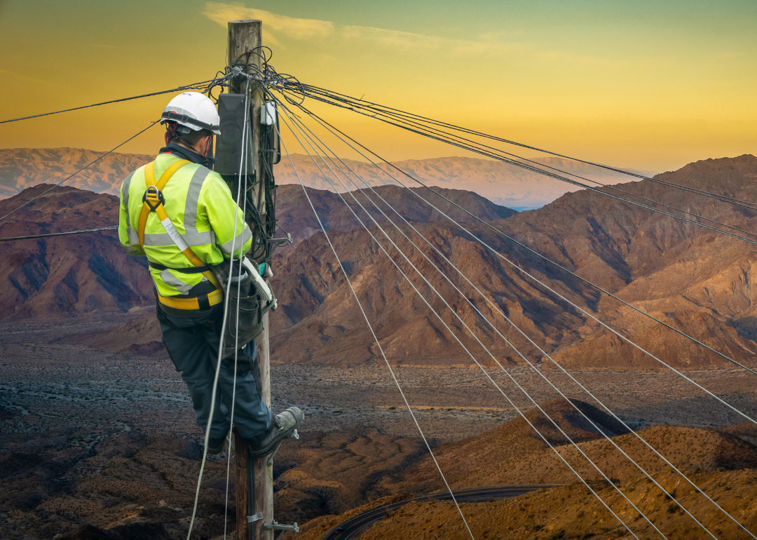 #49. Telecommunications An engineer repairing a desert telephone line.