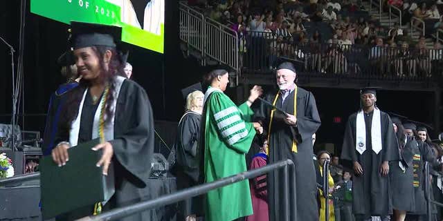 Sam Kaplan walking across stage