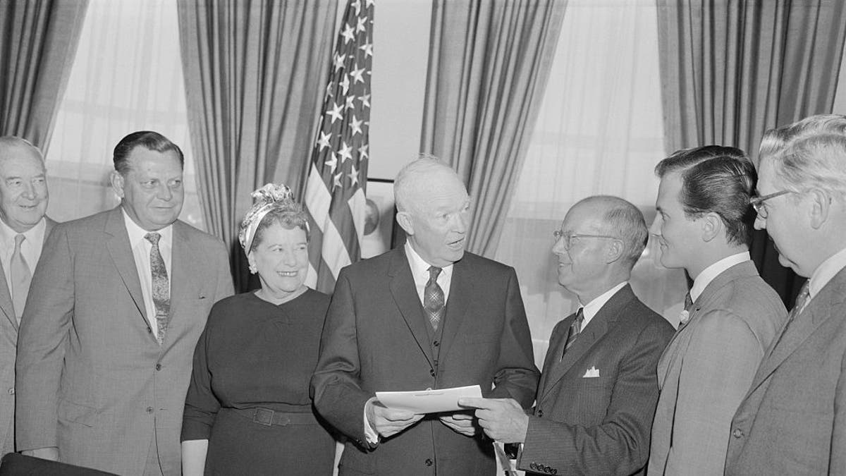 President Eisenhower in oval office with H.E. Humphreys, Jr., chairman of the board of the U.S. Rubber Company; and National Chairman of National Bible Week; and singer pat Boone, right, honorary co-chairman.