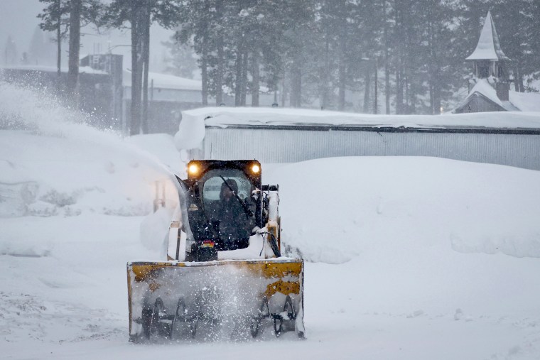 A worker clears snow